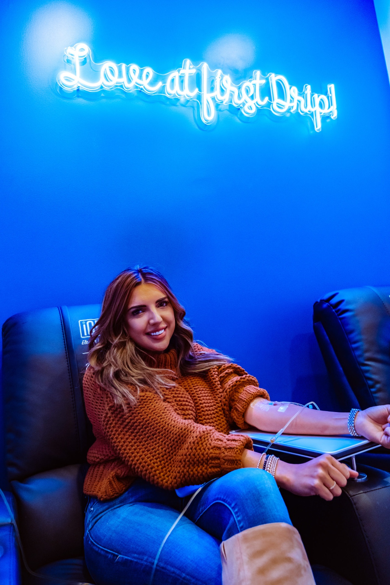 iCRYO Mauldin guest receiving an IV drip under the Love at First Drip neon